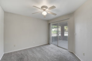 large room with ceiling fan and sliding glass door