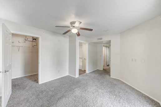 large carpeted room with ceiling fan