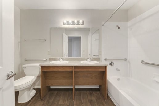bathroom with large mirror and full bathtub
